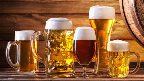 Verschiedene Biersorten uaf Tisch mit Hopfen und Gerste