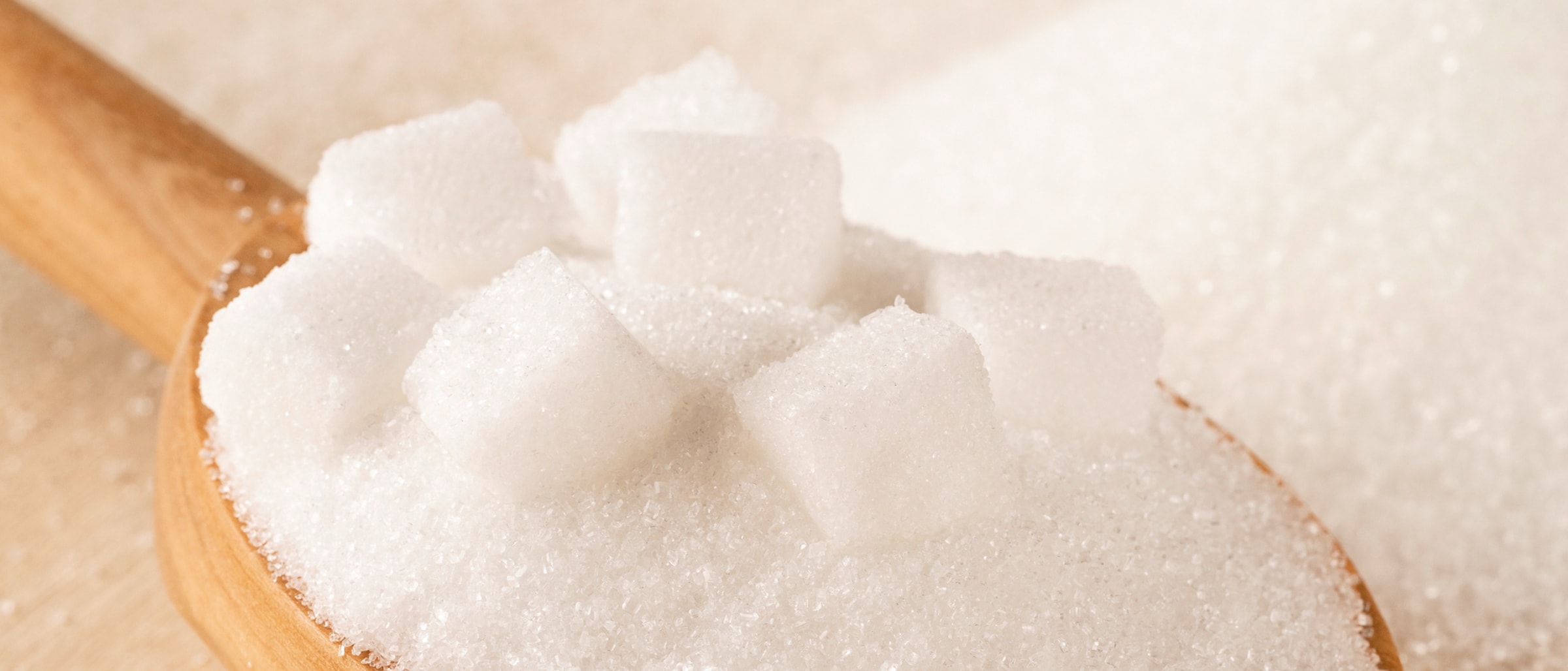 Kochlöffel mit Zuckerwürfeln und weißem Zucker